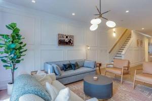 uma sala de estar com um sofá azul e uma escada em The Auden - Peaceful Retreat & Rooftop Panoramas em Nashville