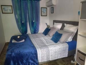 a bedroom with a bed with blue and white pillows at Villa élégante à Sainte-Anne avec piscine privée ouverte toute l'année in Sainte-Anne +40 photos