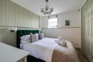 1 dormitorio con 1 cama blanca grande y cabecero verde en Entire house, private parking, great views, dog friendly en Chester