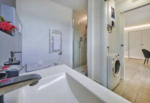 a bathroom with a sink and a washing machine at Majestic Sunrise Bellagio in Bellagio