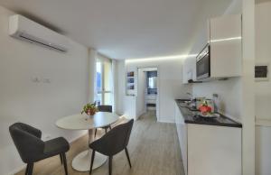 eine Küche und ein Wohnzimmer mit einem Tisch und Stühlen in der Unterkunft Majestic Sunrise Bellagio in Bellagio