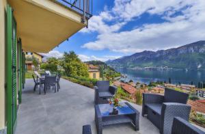 a balcony with chairs and tables and a view of a lake at Majestic Sunrise Bellagio in Bellagio