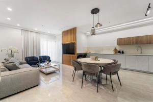 uma sala de estar e cozinha com uma mesa e um sofá em Savyon View 3BDR - ApartHotels In City Center em Jerusalém