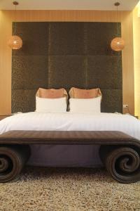 a bedroom with a large bed with two pillows at Madrid Classic Hotel in Hsinchu City