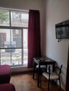 a room with a table and chairs and a window at Hotel Minerva in Buenos Aires