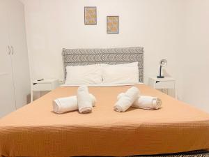 een slaapkamer met een bed met twee handdoeken erop bij Elvita Apartments in Athene