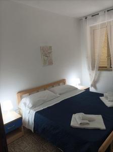 - une chambre avec un grand lit et une couverture bleue dans l'établissement SeaView Apartments Caprioli-Palinuro, à Palinuro