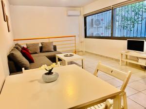 Elvita Apartments في أثينا: غرفة معيشة مع طاولة وأريكة