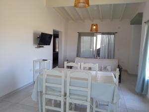 Cañada La Negra的住宿－Casa Nuevo Sol，白色的用餐室配有白色的桌椅