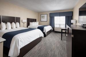 a hotel room with two beds and a television at Stonecroft Inn in Windsor