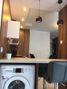 una cocina con lavadora bajo una barra en Apartments DeLuxe Center NOWY ŚWIAT, en Białystok