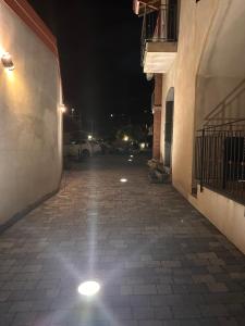une rue vide la nuit avec un bâtiment dans l'établissement B&B Dimora dell' Etna, à Milo
