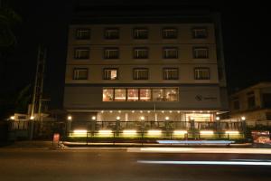 迪布鲁加尔Hotel Tree Fern的建筑前有灯的高楼