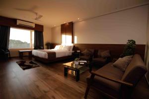 迪布鲁加尔Hotel Tree Fern的配有床和沙发的酒店房间