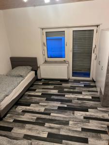 a bedroom with a bed and two windows at Ferienwohnung-Monteurwohnung in Homburg