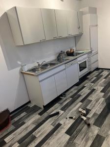 a kitchen with white cabinets and a sink at Ferienwohnung-Monteurwohnung in Homburg +13 photos