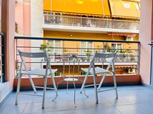 two chairs and a table on a balcony at Elvita Apartments in Athens