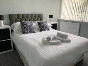 a white bed with towels and pillows on it at Quiet Ground Floor apartment with parking in Morecambe