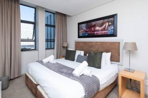 a bedroom with two beds and a tv on the wall at Chic 1-Bedroom Apartment In The Heart Of The City in Cape Town
