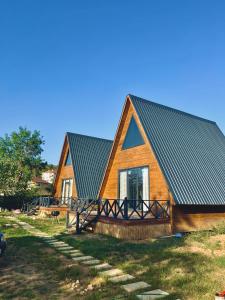 a wooden house with a metal roof on a field at Ağva Bungalov Evler @lidiamare_ 