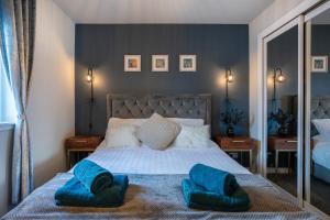 a bedroom with a bed with blue towels on it at Central-1Bed Flat-Free Parking in Aberdeen