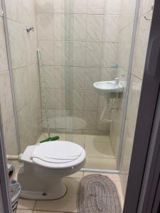 uma pequena casa de banho com WC e lavatório em casa de praia em Santos