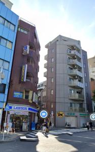 two tall buildings on a city street with people walking at TOKYO SHINJUKU MIO HOTEL in Tokyo