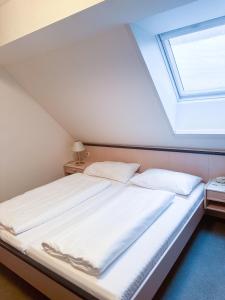 a bedroom with a large bed with a skylight at Gasthof & Buschenschank Windisch in Gundersdorf