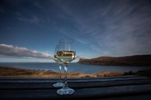 a glass of wine sitting on top of a table at Dark Skye Cottage in Milovaig