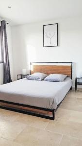 uma cama num quarto com duas mesas de cabeceira em Gîte du Colombier em Crestet