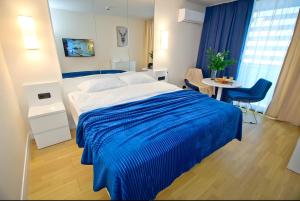 a bedroom with a large bed with a blue blanket at Panorama Sea View Orbi City Aparthotel Batumi Beach in Batumi