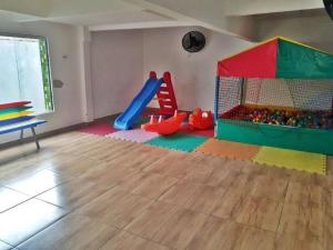 a room with a playground with a slide and play equipment at Apartamento na aviação in Praia Grande