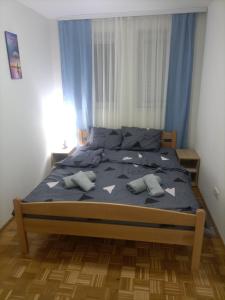 a bedroom with a bed with blue sheets and pillows at JelaLux in Gornja Toplica