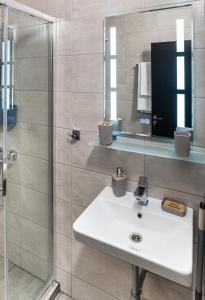 a bathroom with a white sink and a shower at St George Apartcomplex in Shkorpilovtsi