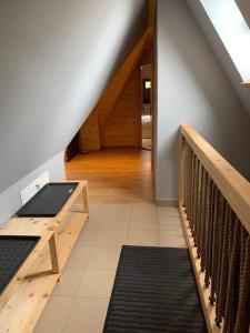 a room with wooden floors and a staircase with benches at Bacówka Na Bundówkach in Zakopane