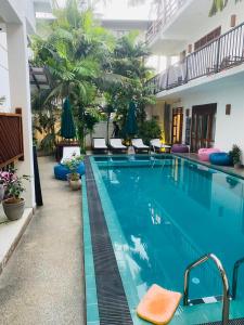 une grande piscine dans un hôtel avec des chaises dans l'établissement Bienvenido Cozy Marker, à Matara