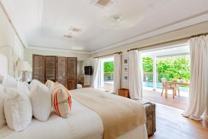 a bedroom with a large bed with white pillows at Hotel Le Toiny in Gustavia