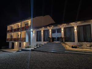 a building at night with stairs and lights at Flori de Tei Maramures in Săcel