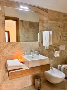 bagno con lavandino bianco e specchio di Alloggio Aquila d'Oro a Creazzo