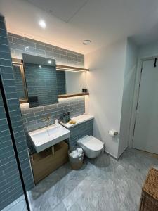 a bathroom with a sink and a toilet at Stylish Brentford Riverside Penthouse in Brentford