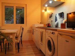 uma cozinha com uma máquina de lavar roupa e uma mesa com cadeiras em Loft ravissant proche du centre-ville em Nîmes