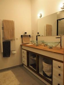 uma casa de banho com 2 lavatórios de vidro e um espelho em Loft ravissant proche du centre-ville em Nîmes
