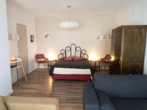 um quarto com uma cama e uma sala de estar com um sofá em Loft ravissant proche du centre-ville em Nîmes