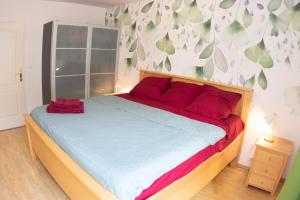 um quarto com uma cama grande e almofadas vermelhas em Kasa Jura 2 - Centre ville - Proche pistes de ski em Saint-Claude