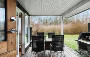 a patio with a table and chairs on a porch at 3 Bedroom Amazing Home In Nysted in Nysted