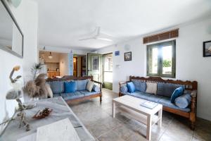 uma sala de estar com dois sofás azuis e uma mesa em RURAL GUEST HOUSE B&B em Chavouna