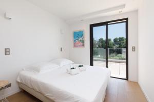 ein weißes Schlafzimmer mit einem großen Bett und einem Fenster in der Unterkunft HSUD0059-Les Ecrins in Mougins