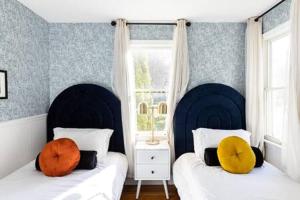 ein Schlafzimmer mit zwei Betten und einem Fenster in der Unterkunft Cape Escape - Springtime Golfing & Walk to The Bay! in Mashpee