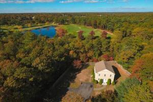 einem Luftblick auf ein Haus und einen See in der Unterkunft Cape Escape - Springtime Golfing & Walk to The Bay! in Mashpee