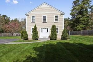 ein weißes Haus mit einem Garten mit Bäumen und einer Auffahrt in der Unterkunft Cape Escape - Springtime Golfing & Walk to The Bay! in Mashpee + 41 Fotos